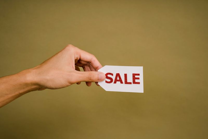 woman holding a sale sign