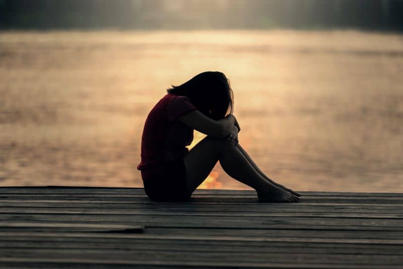 grieving woman on a pier wondering How to Deal With Hedgehog Deaths