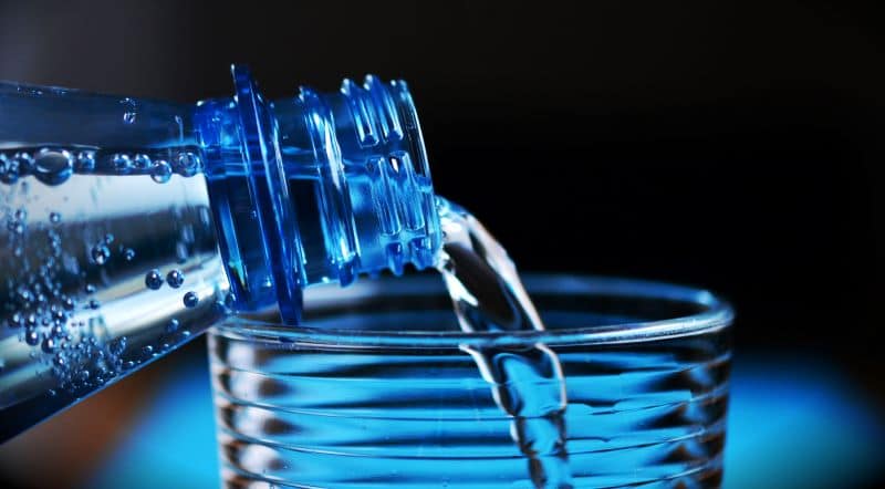 bottled water being poured into a glass