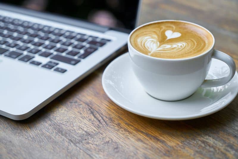 cup of coffee near a Macbook as hedgehog owner asks Can Hedgehogs Drink Coffee?