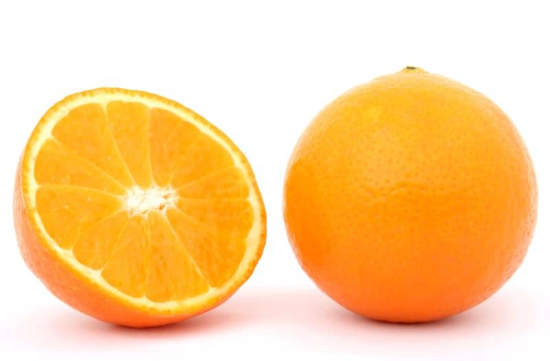 peeled and full orange lying side by side